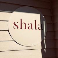 a sign that says shala on the side of a building
